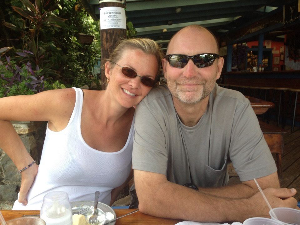 A man and a woman are posing for a picture while sitting at a table