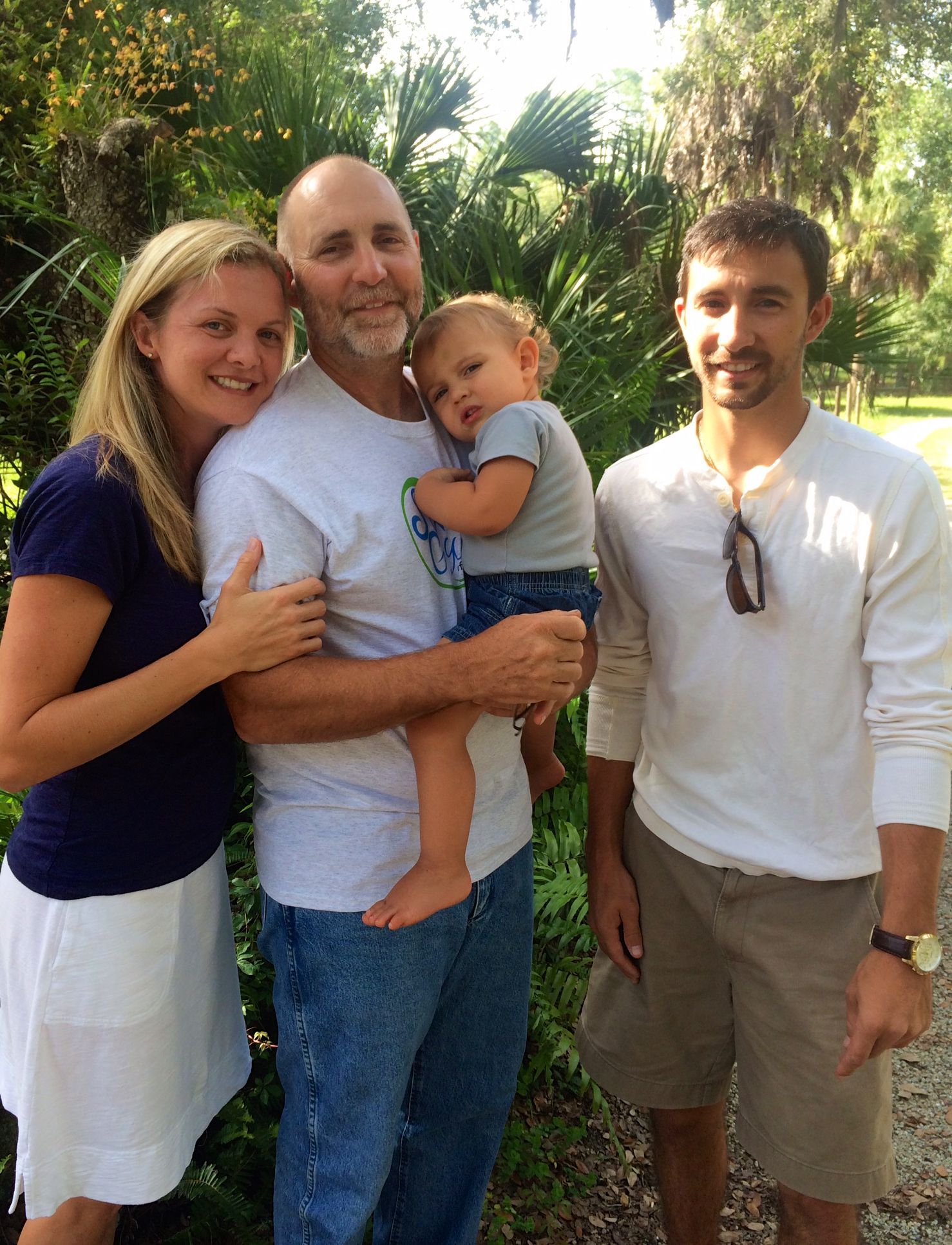 A group of people posing for a picture with one man holding a baby