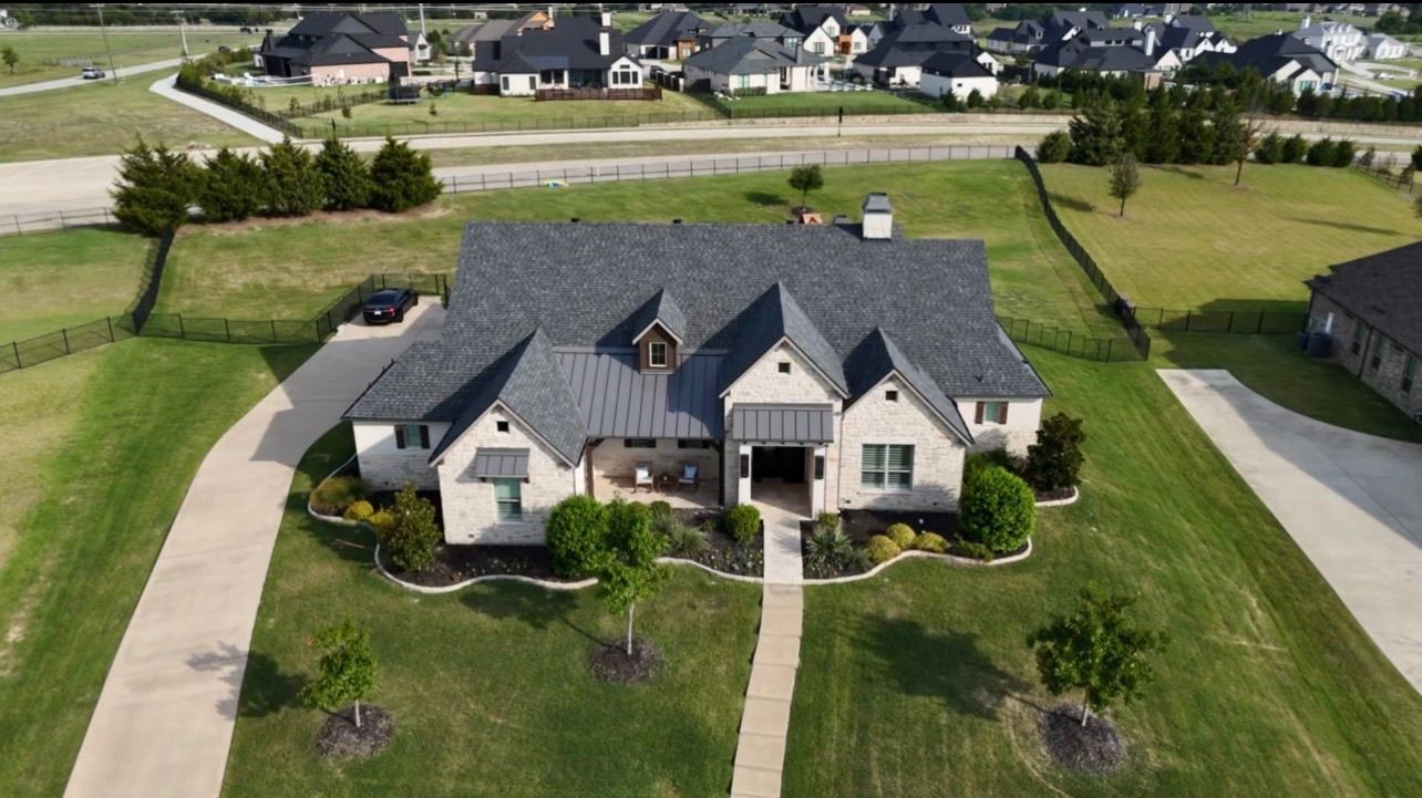 An aerial view of a large house in a residential area