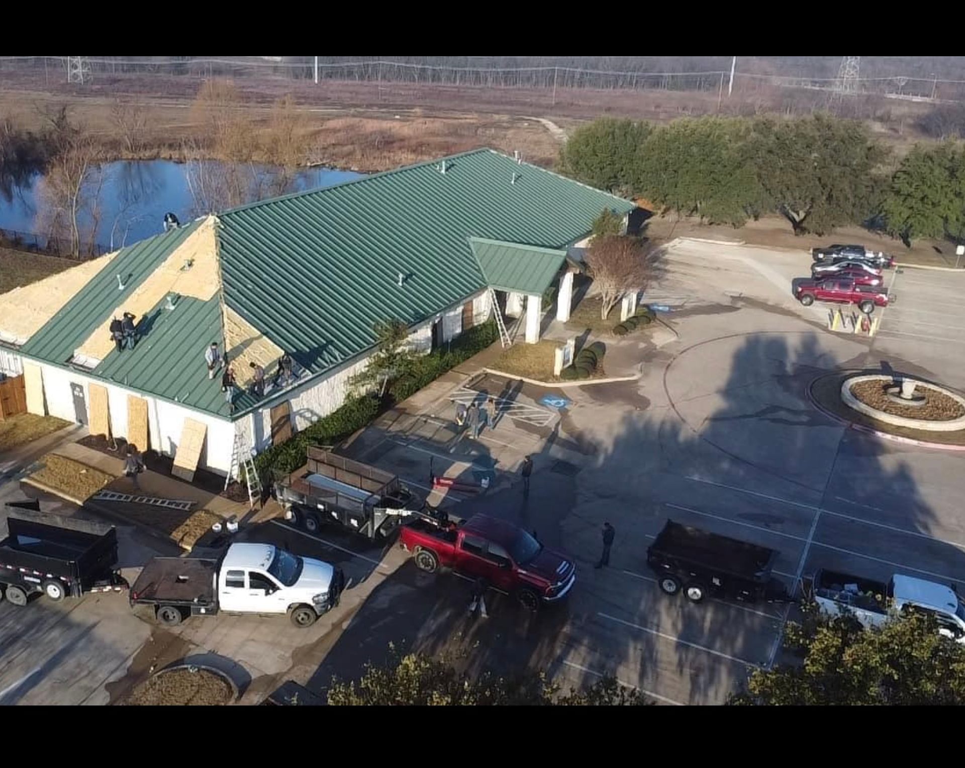 An aerial view of a building with a green roof being installed