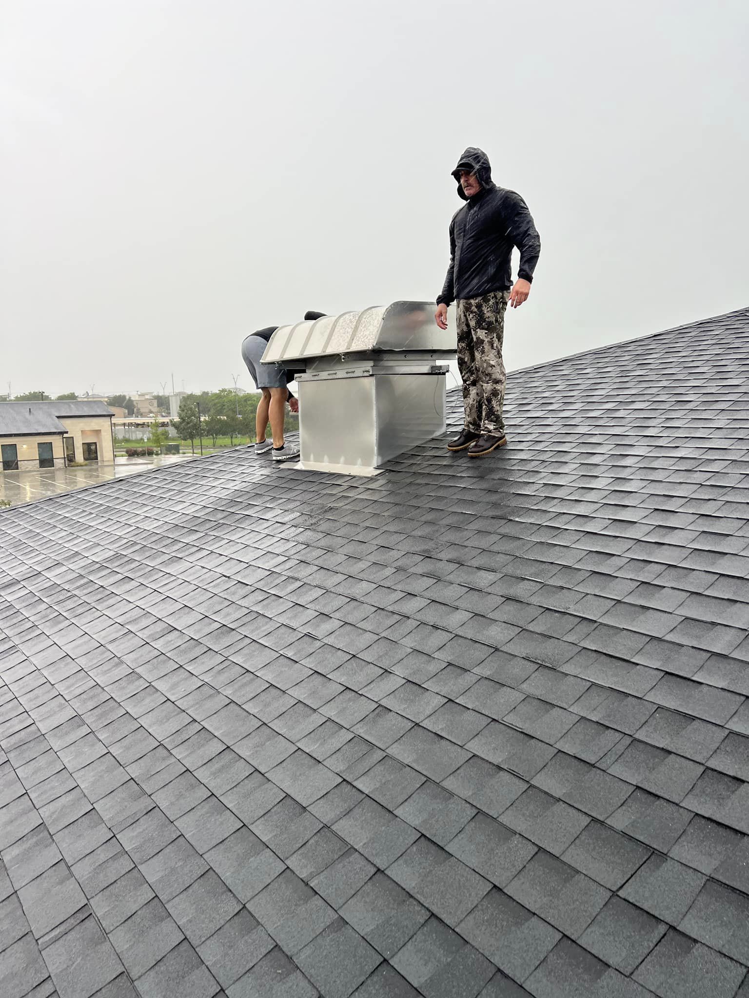 A man is standing on top of a roof.
