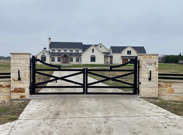 A large white house with a black gate in front of it.