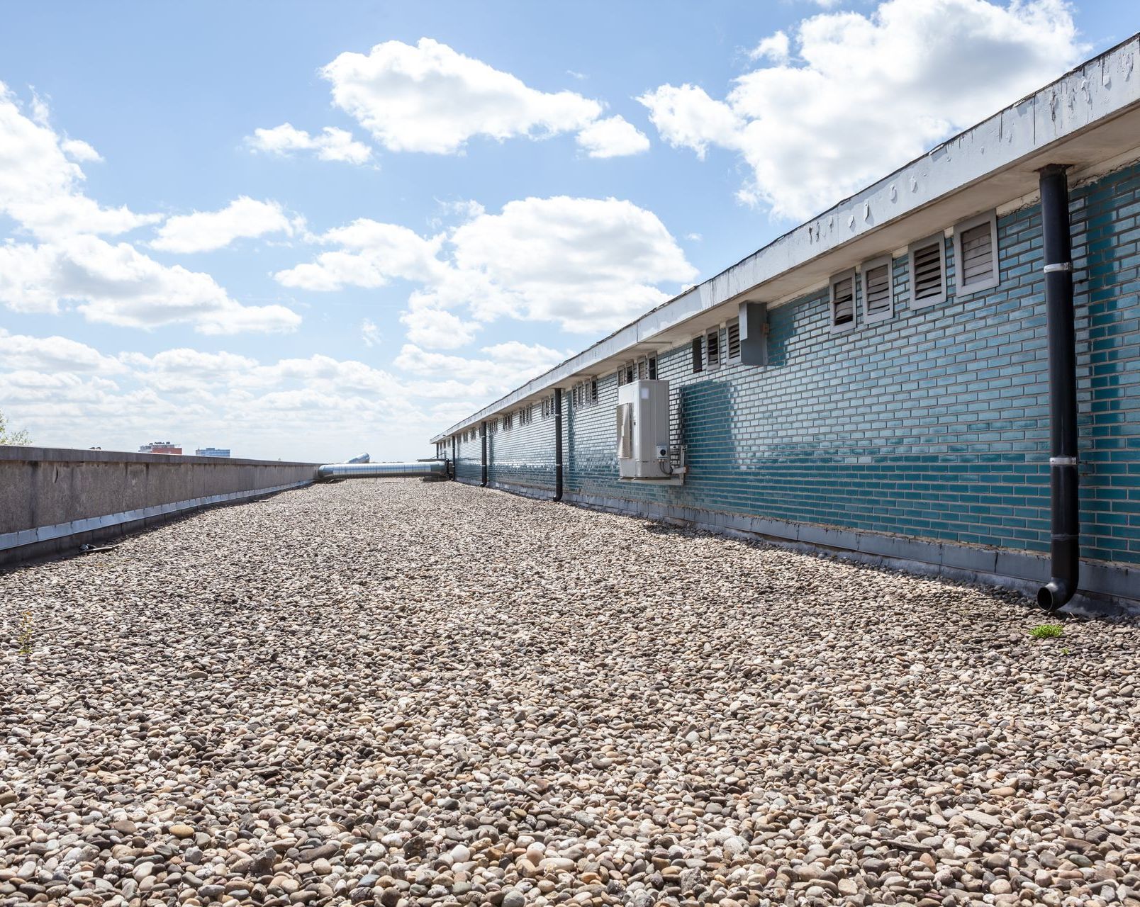 There is a lot of gravel on the roof of a building.