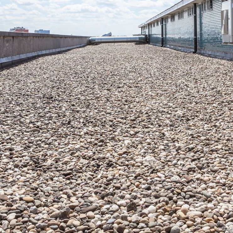 A pile of gravel on the roof of a building.