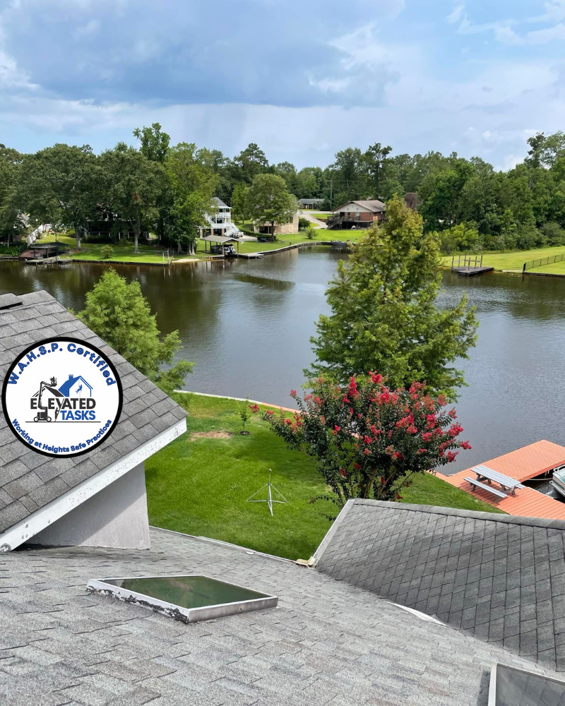 A lake view from a roof with the company logo on the corner. Sunny day with trees and houses.
