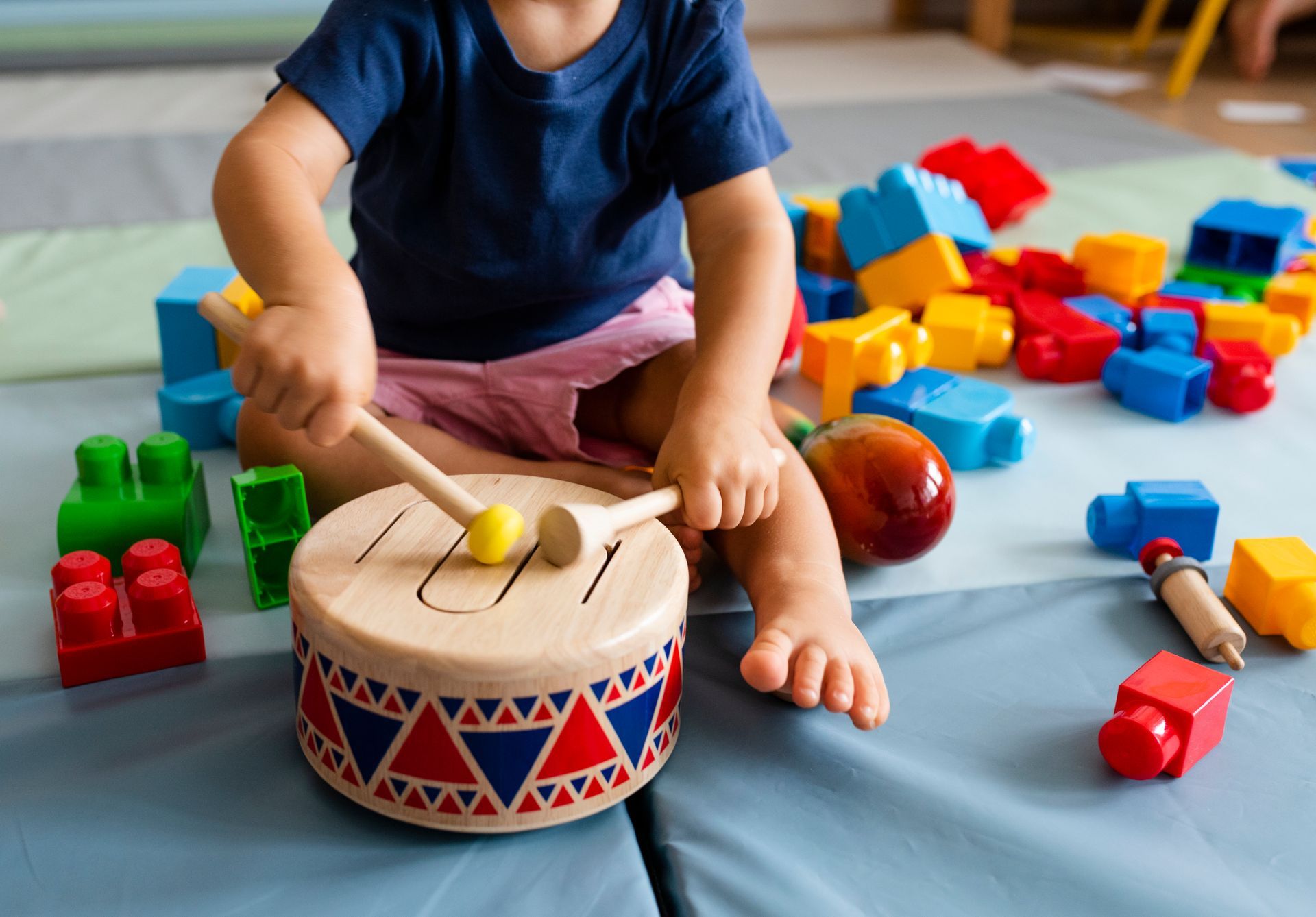 Toddler drumming on a toy