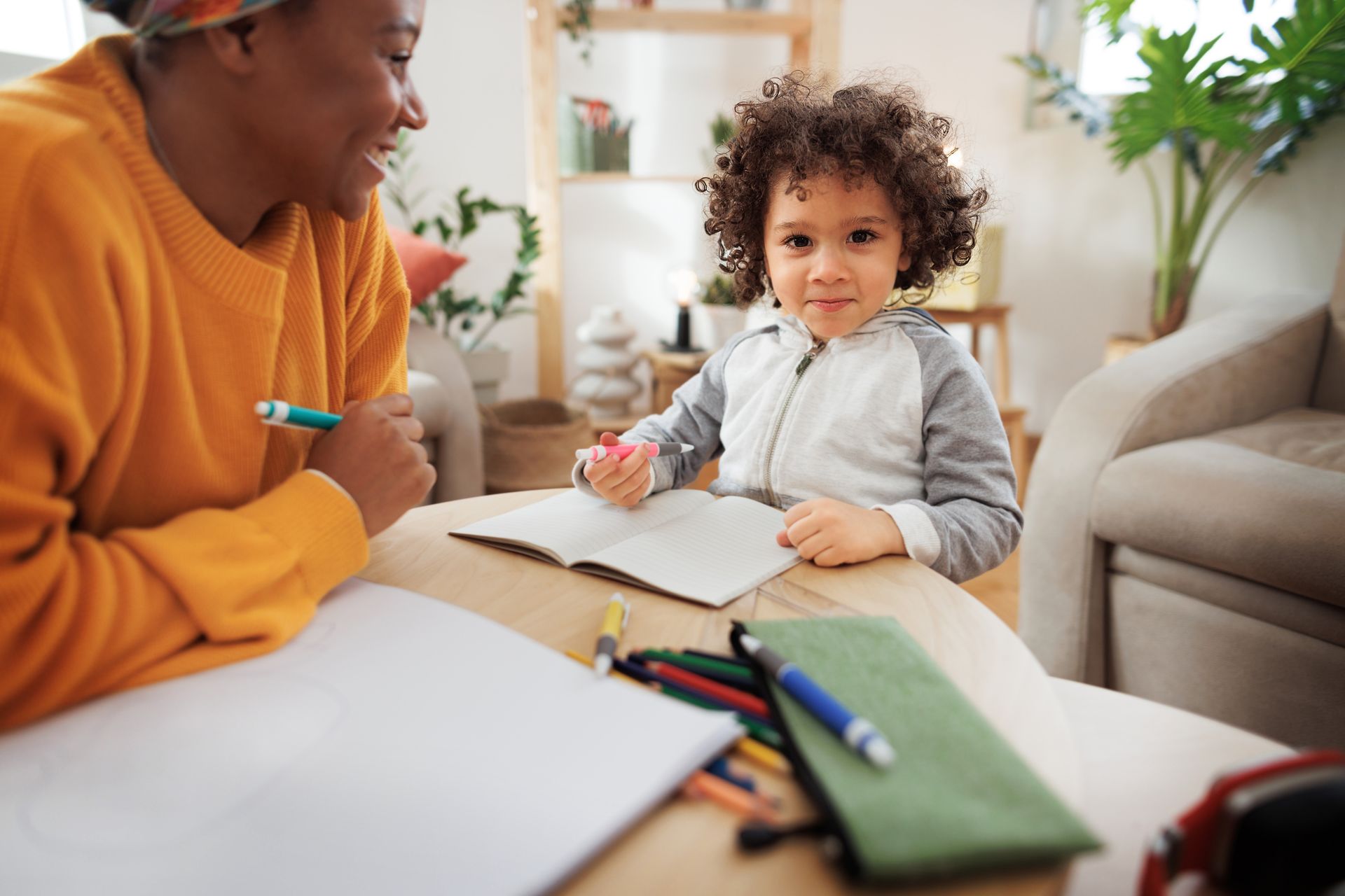 A woman is sitting at a table with a child.