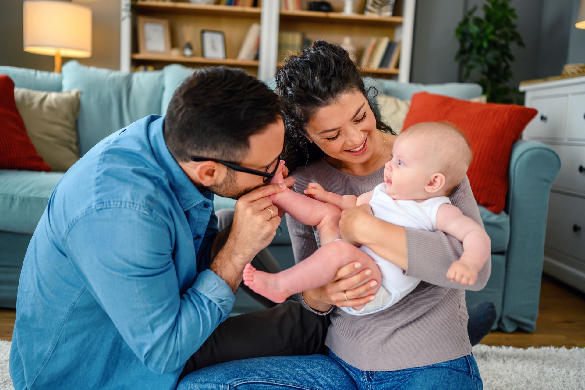 Parents cuddling and snuggling a baby.