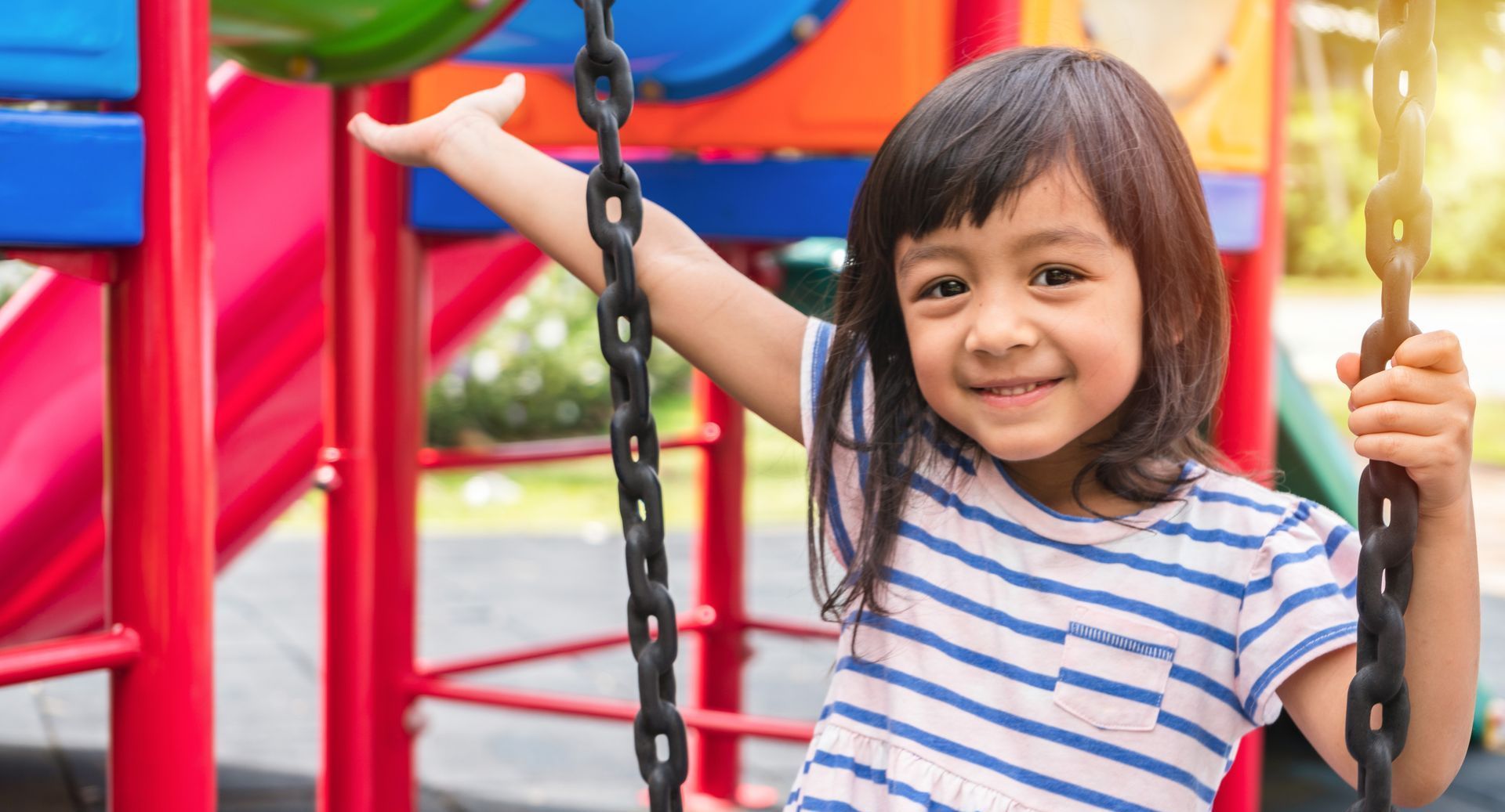 Child on a playground smiling.