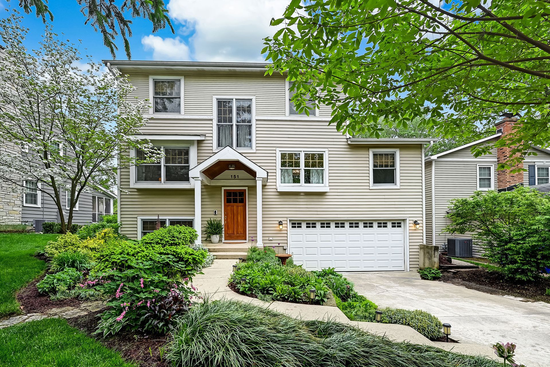 The front of a house with a large garage and a walkway leading to it.