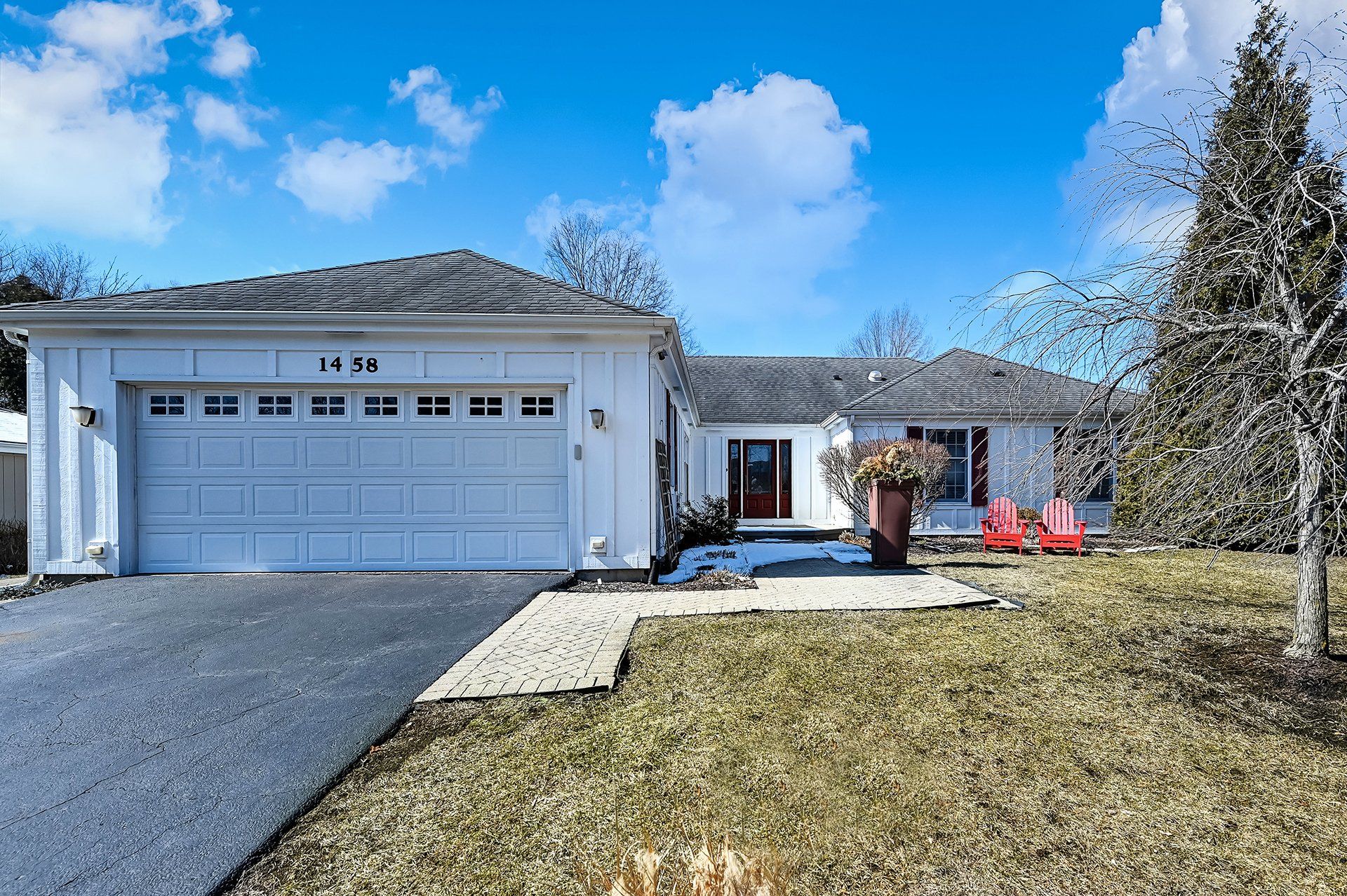 A white house with a large garage and a driveway