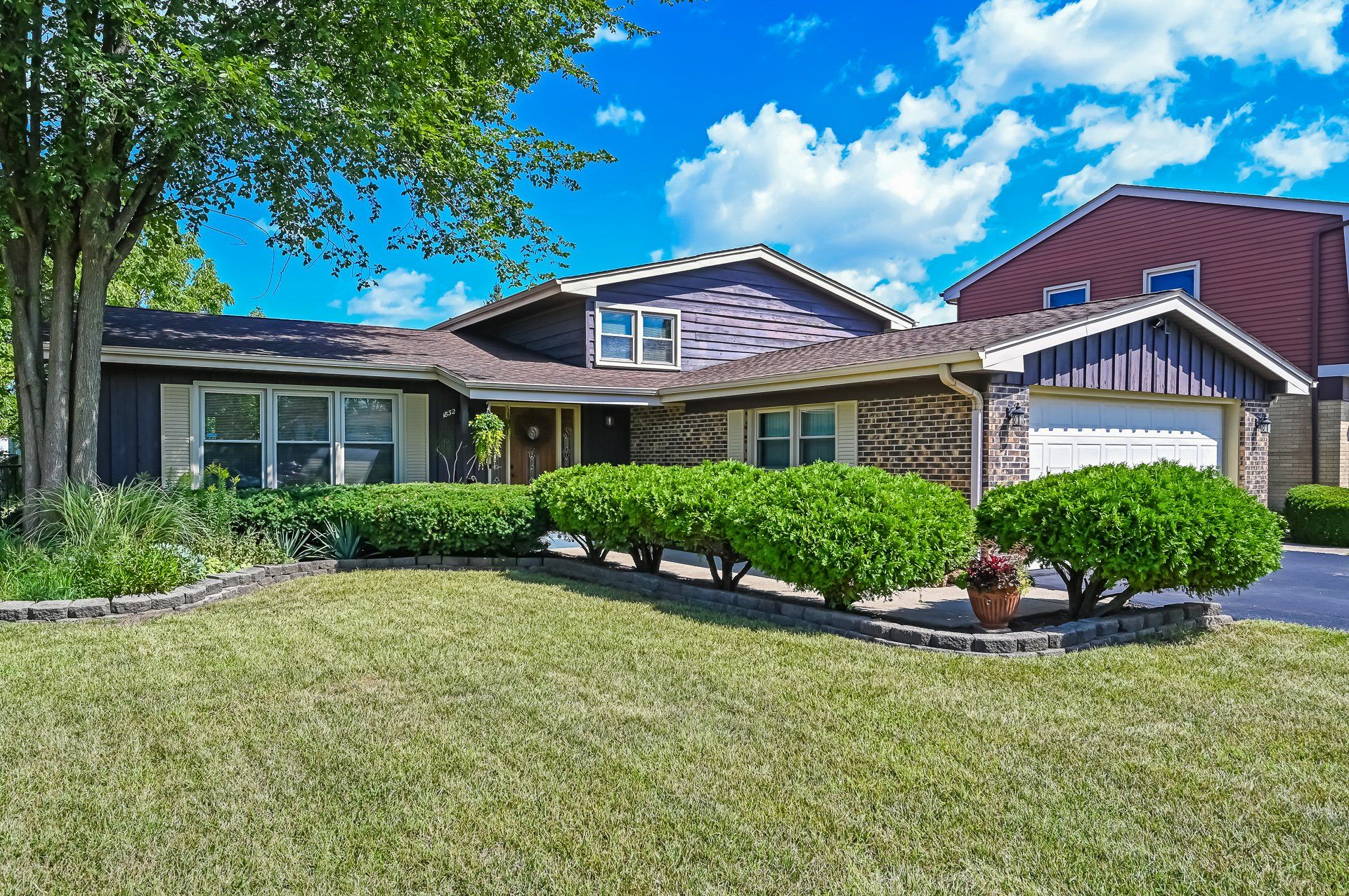 A house with a lush green lawn in front of it