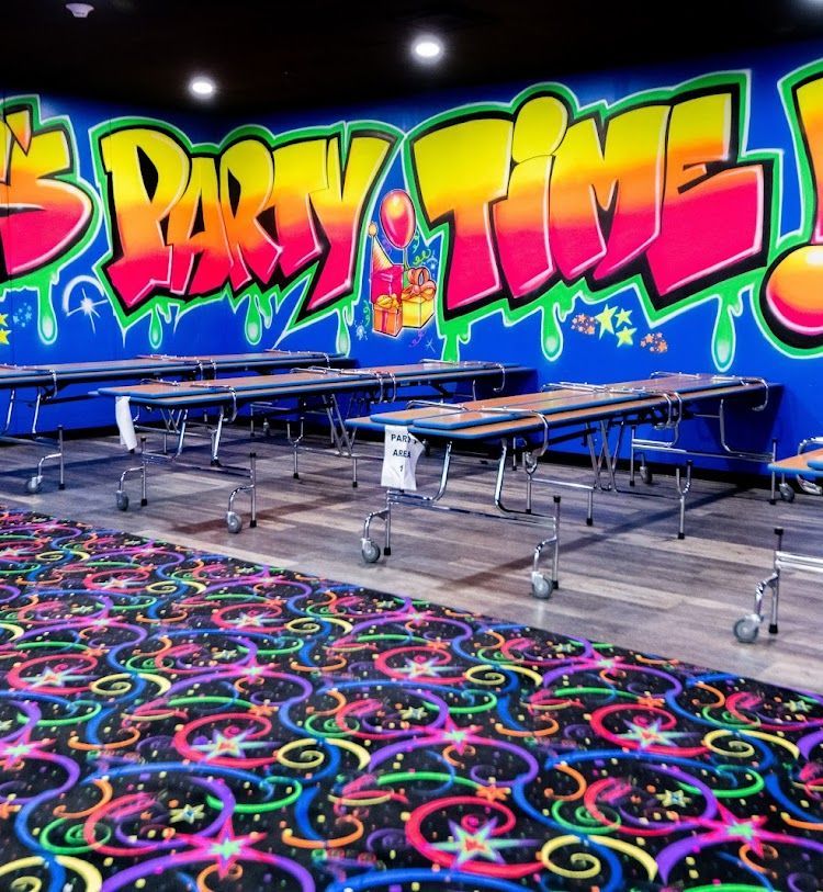 A room with tables and a wall that says party time