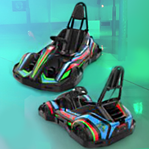 Two go karts are sitting next to each other on a green surface.