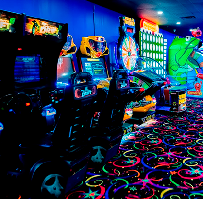 A bunch of arcade games are lined up in a room