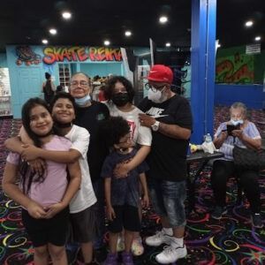 A group of people are posing for a picture in a roller rink.