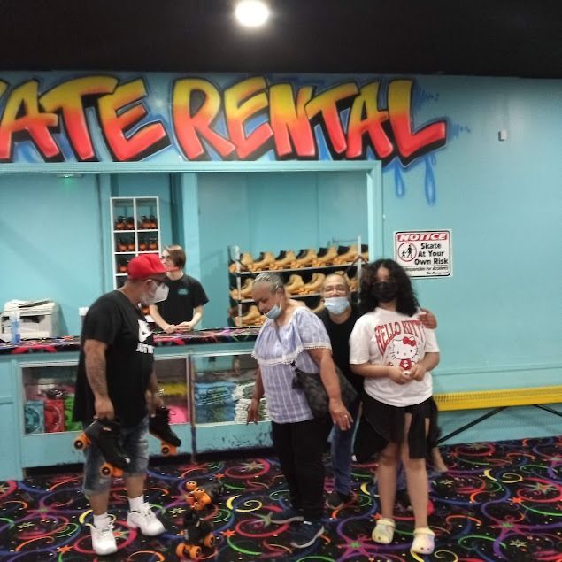 A group of people standing in front of a skate rental sign