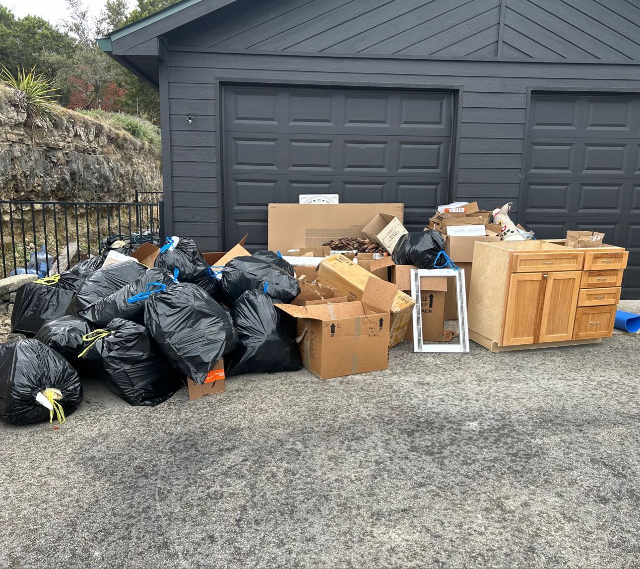 A pile of furniture and a chair are sitting on the sidewalk.