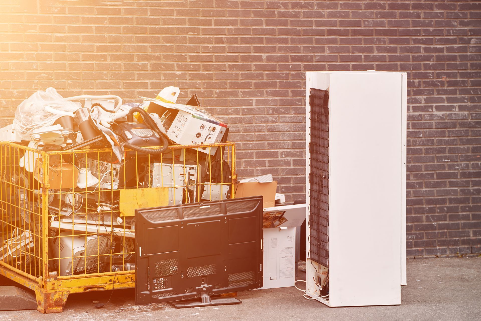 A pile of junk is sitting in front of a brick wall.