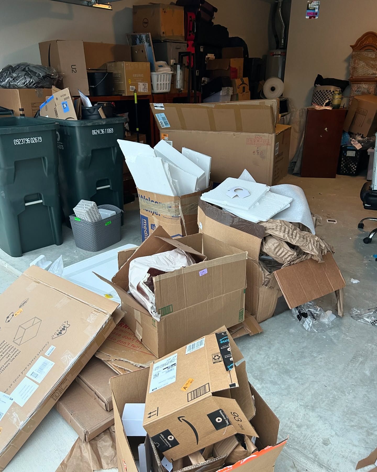 A garage filled with lots of cardboard boxes and trash cans