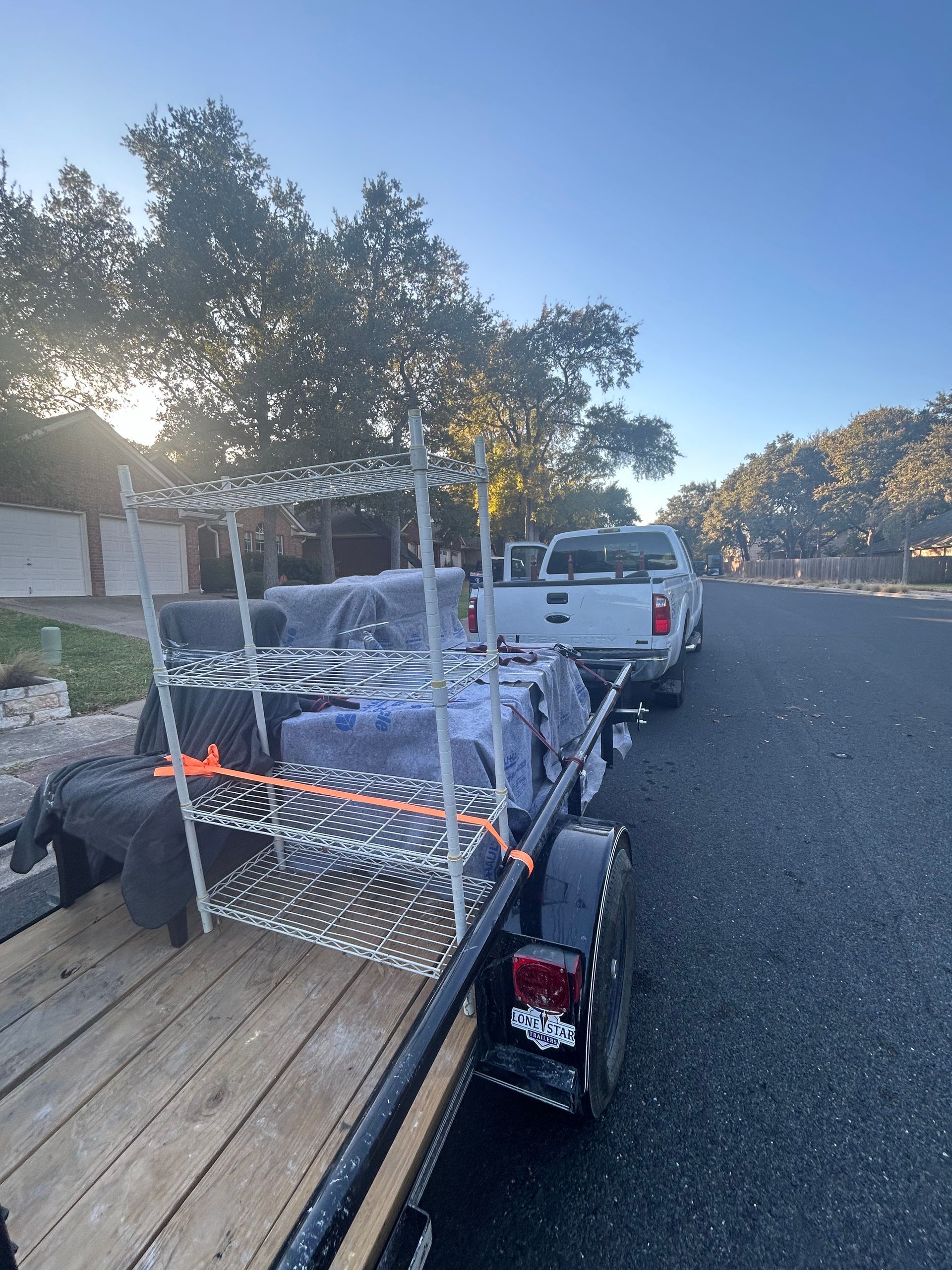 A trailer is parked on the side of the road next to a truck.