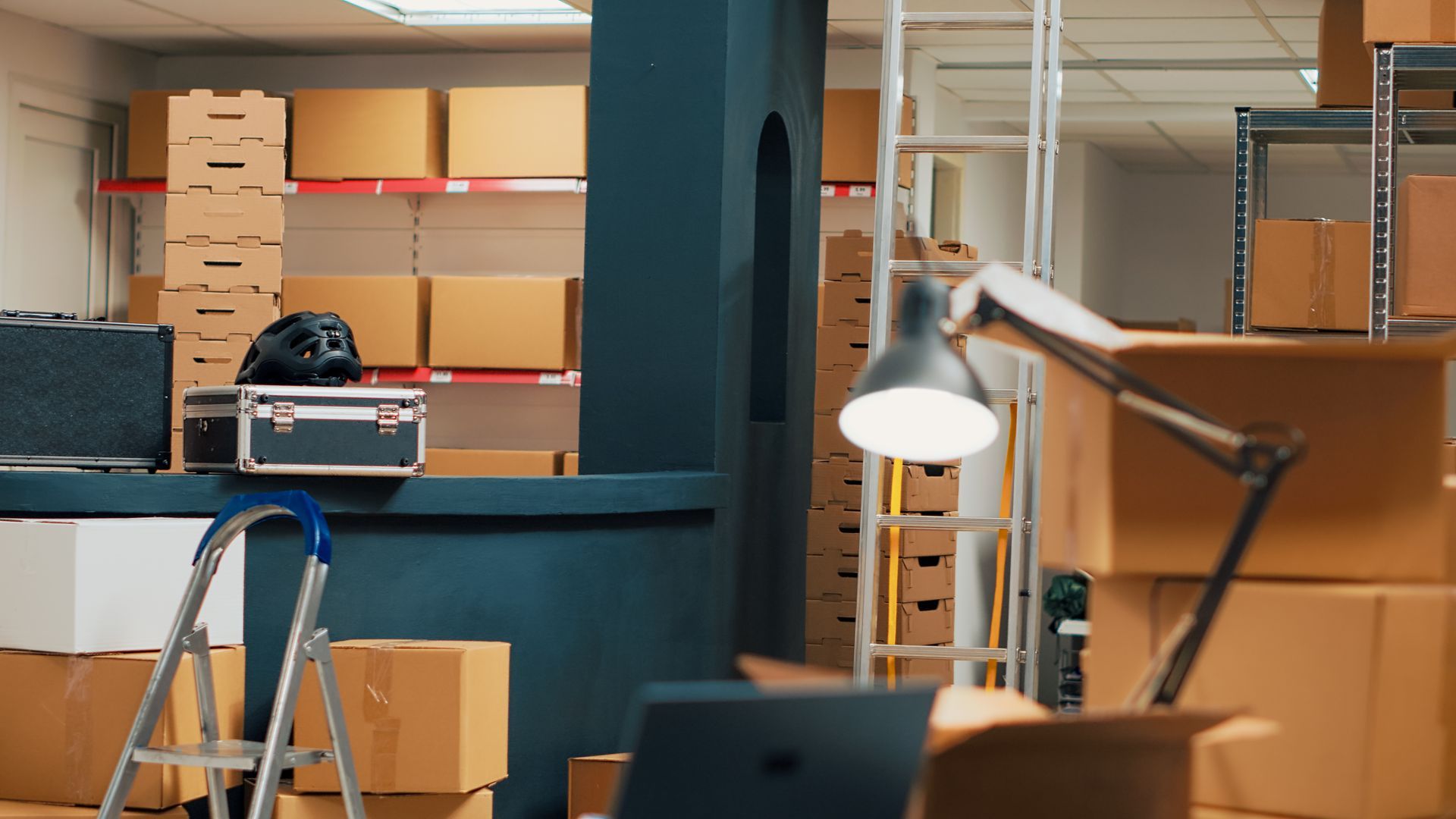 A warehouse filled with lots of cardboard boxes and a laptop.