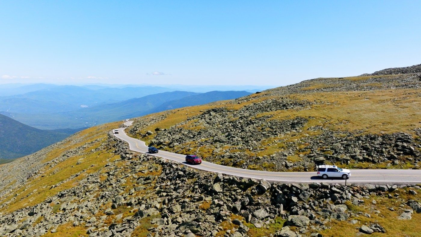 car driving up road with mountains