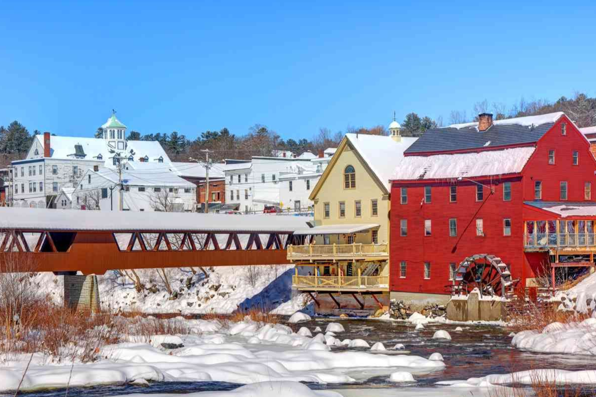 littleton nh main street on the river with covered bridge in the winter with snow