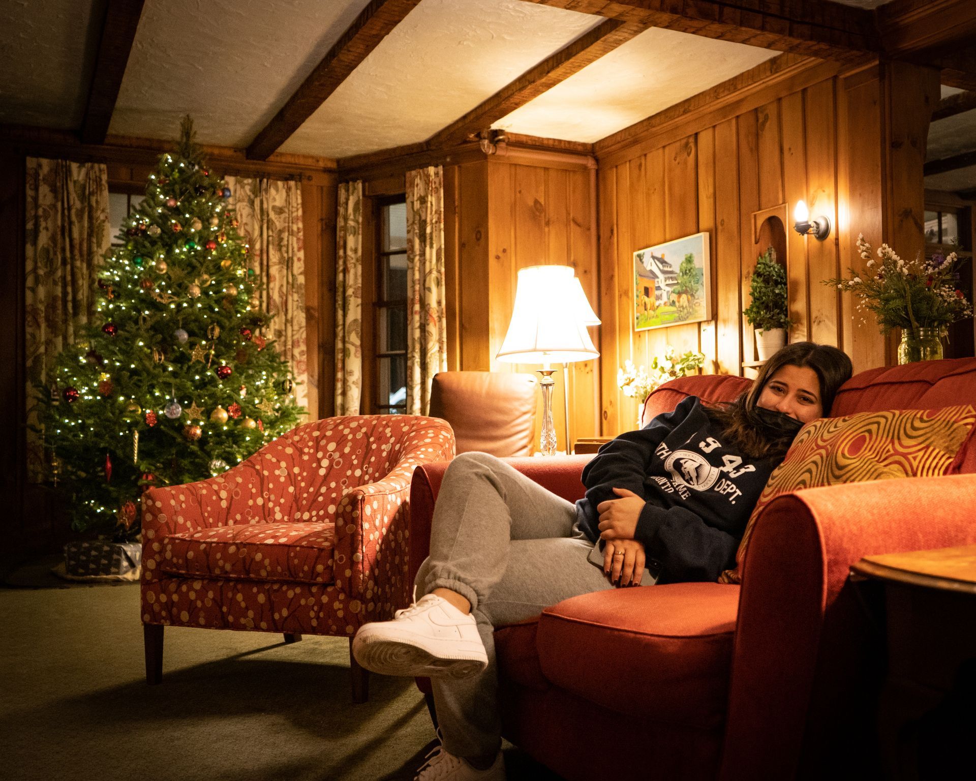 person sitting in a cozy living room with a christmas tree in the background