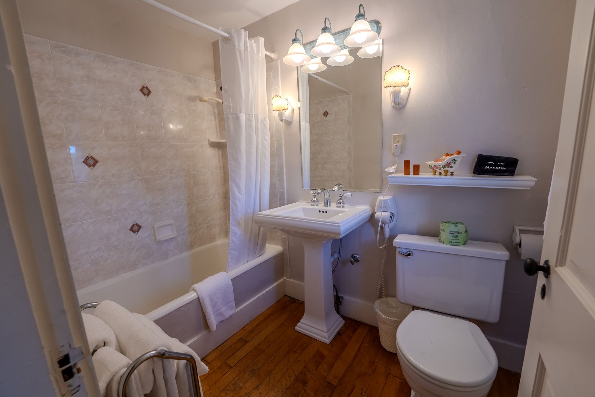 Bathroom with pedestal sink, toilet, and shower/tub combo. White and beige color scheme.