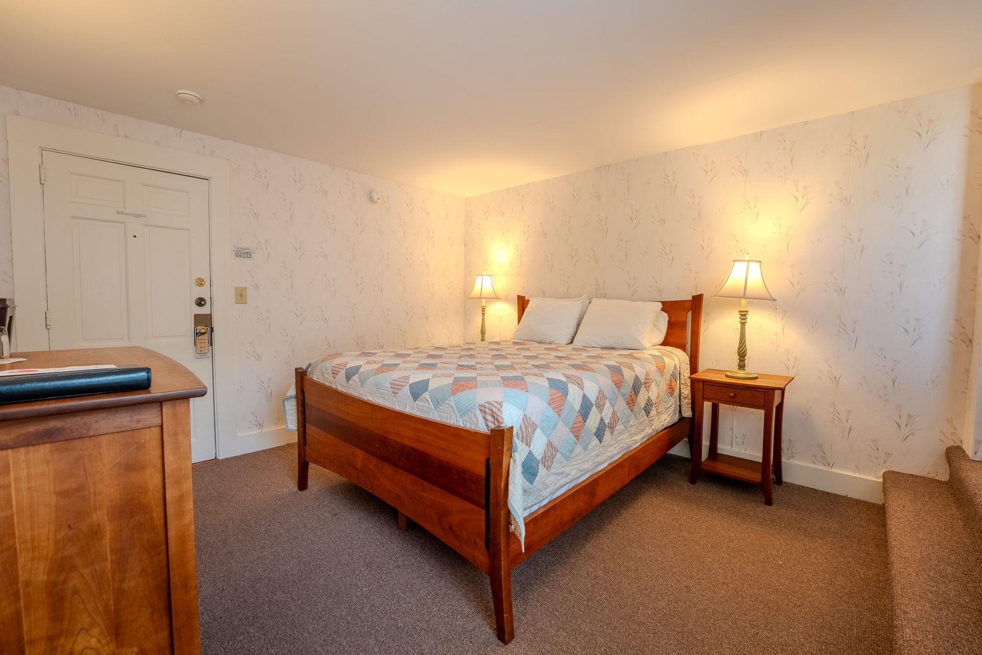 Bedroom with a wooden bed, two lamps, and a nightstand.