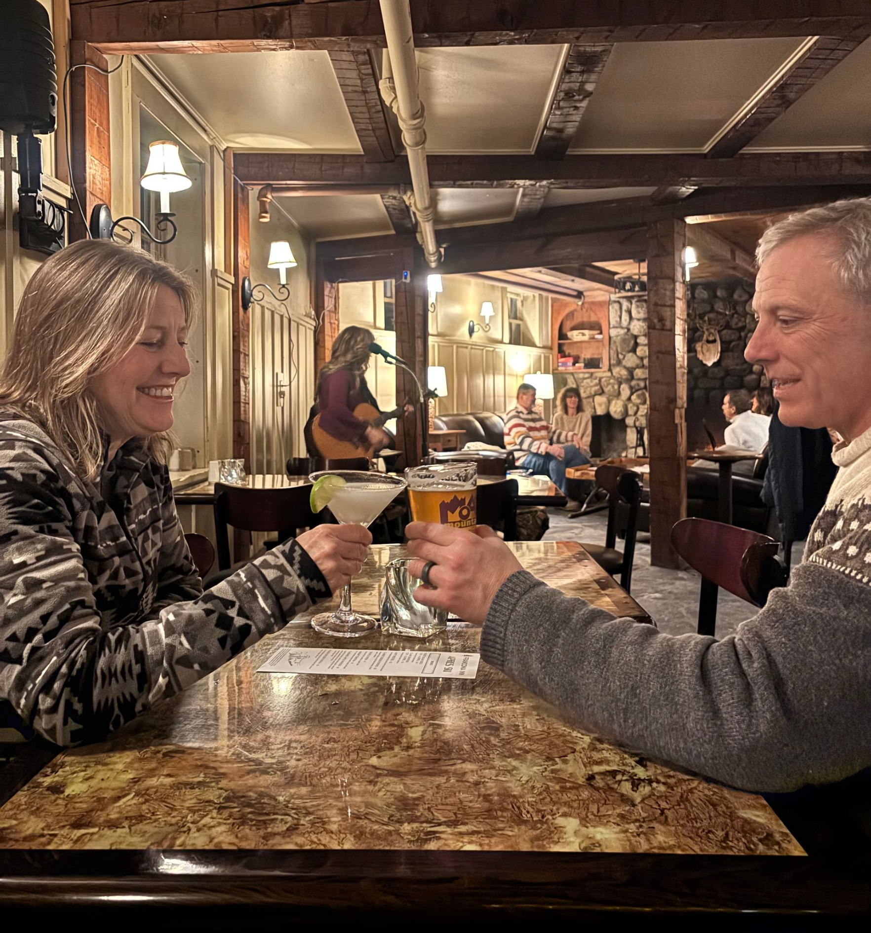 two people dining in a pub with cocktails