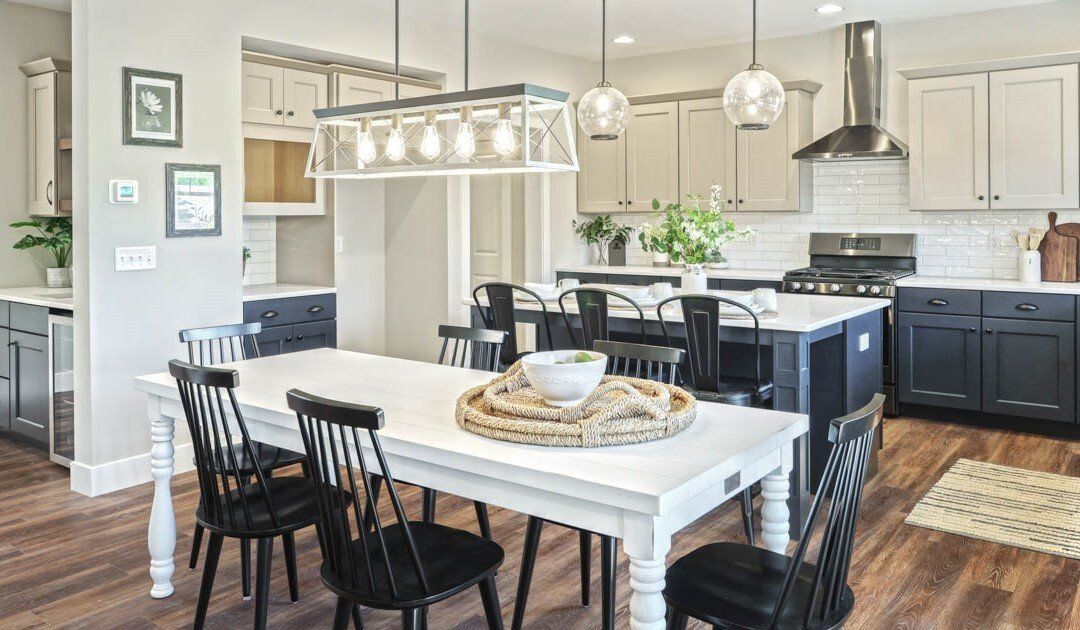 Open kitchen design in new home with pendant and linear lights over dining table