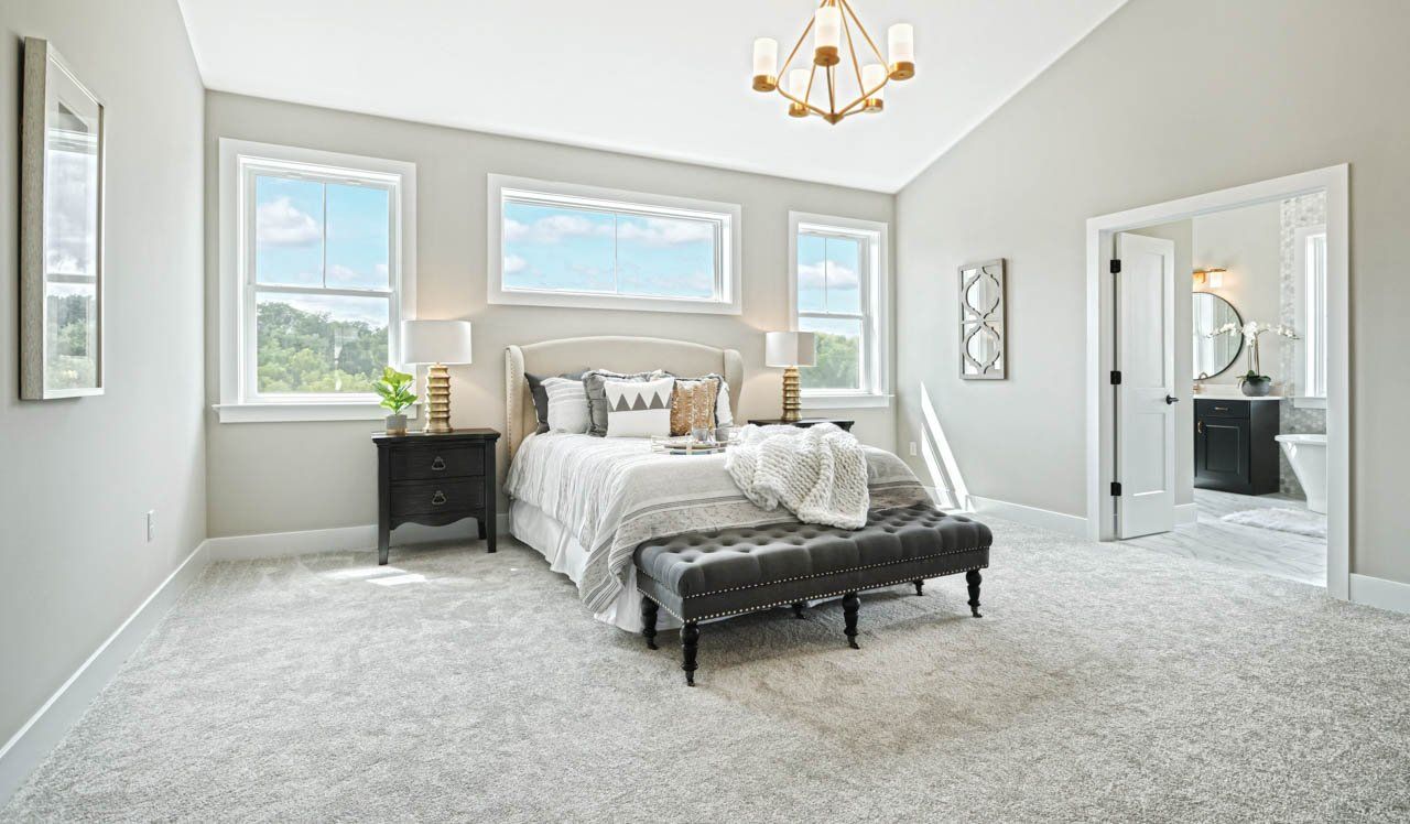 Owner's suite with brushed bronze lighting fixture in new home home