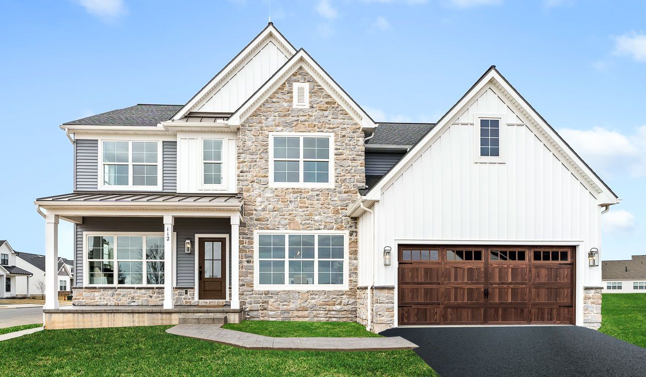 A large house with a large garage and a porch.