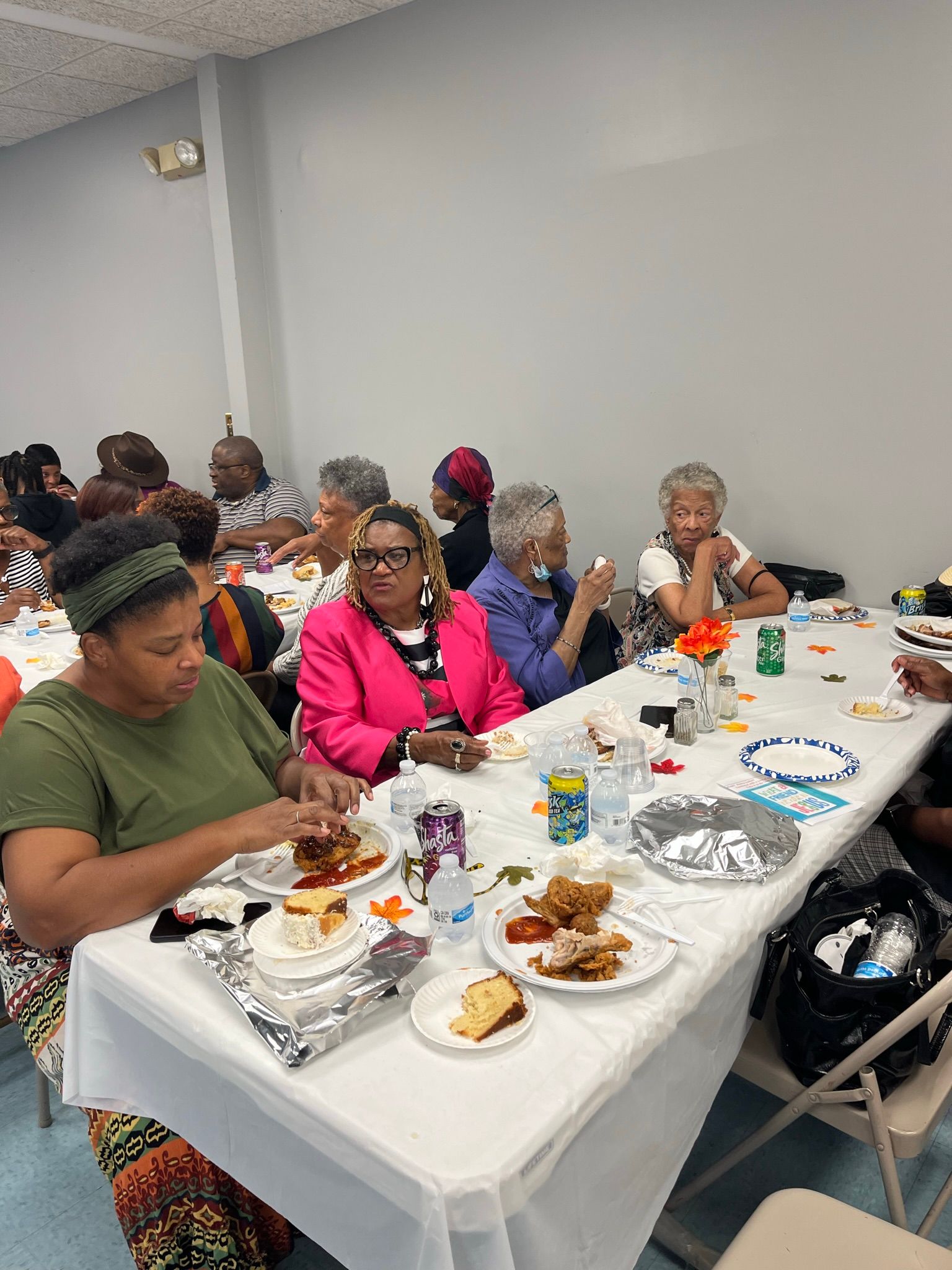 A group of people are sitting at tables eating food.