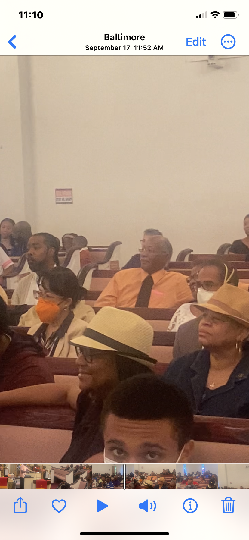 A group of people are sitting in a church wearing face masks.