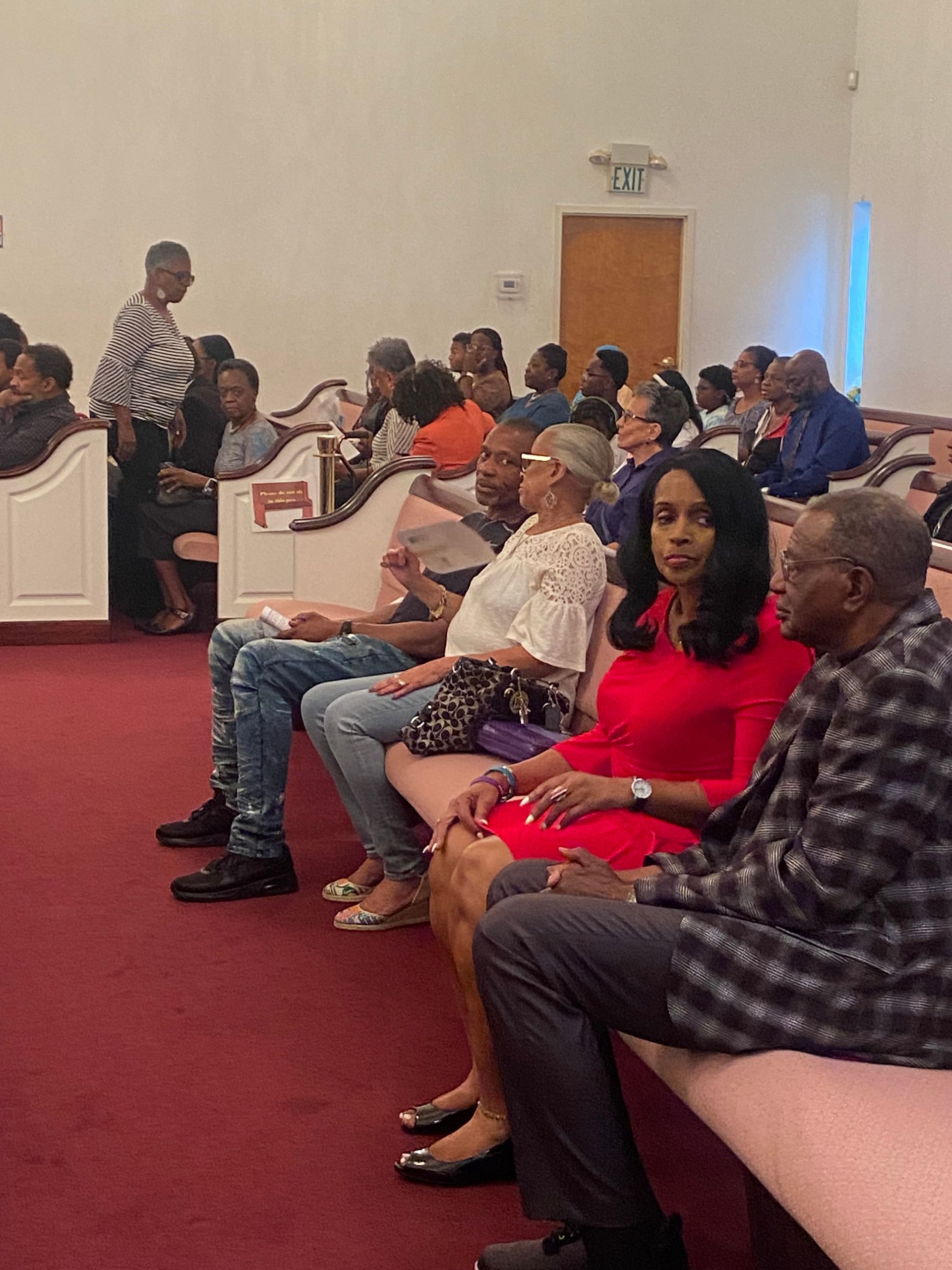 A group of people are sitting on benches in a church.