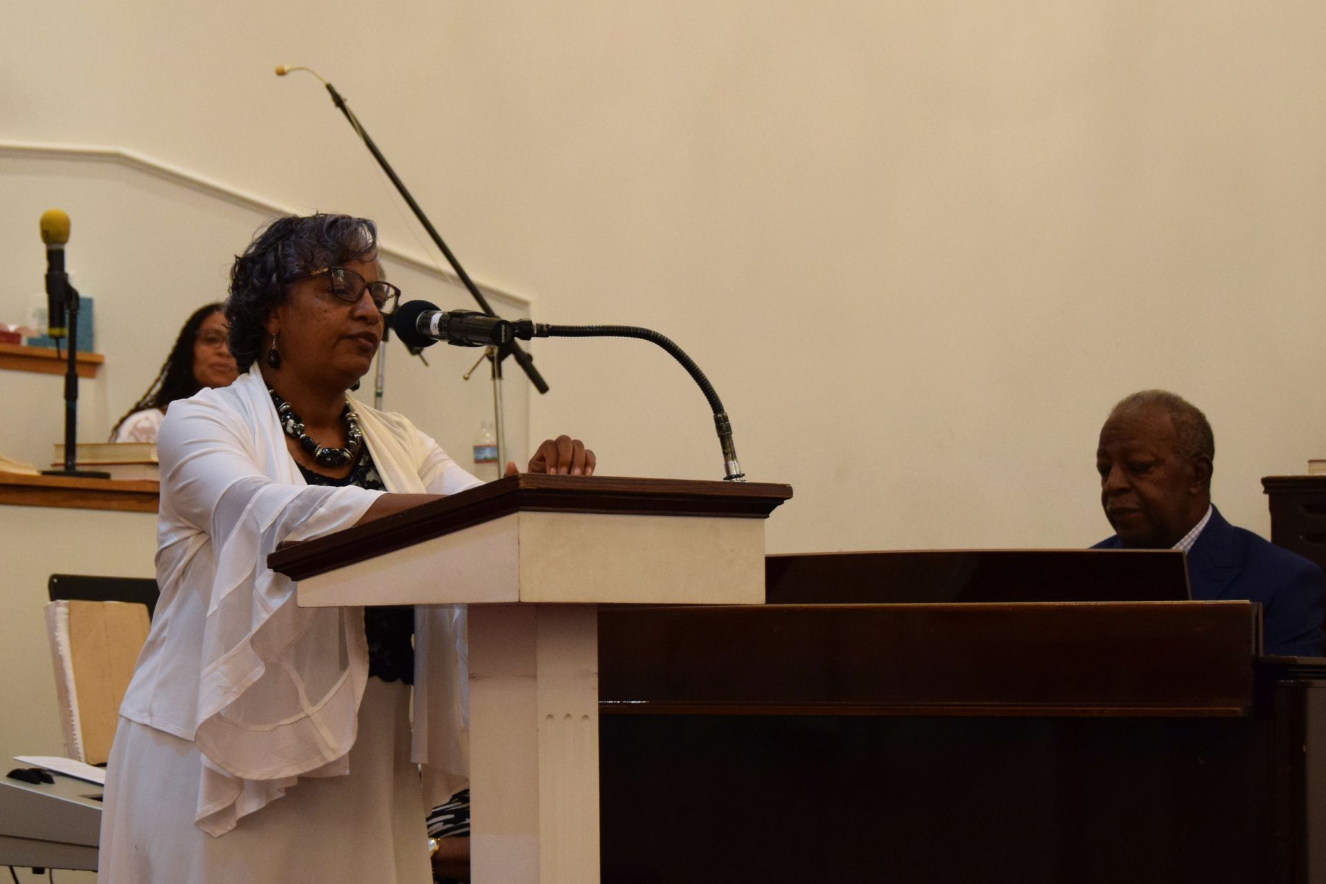 A woman is standing at a podium giving a speech in front of a microphone.