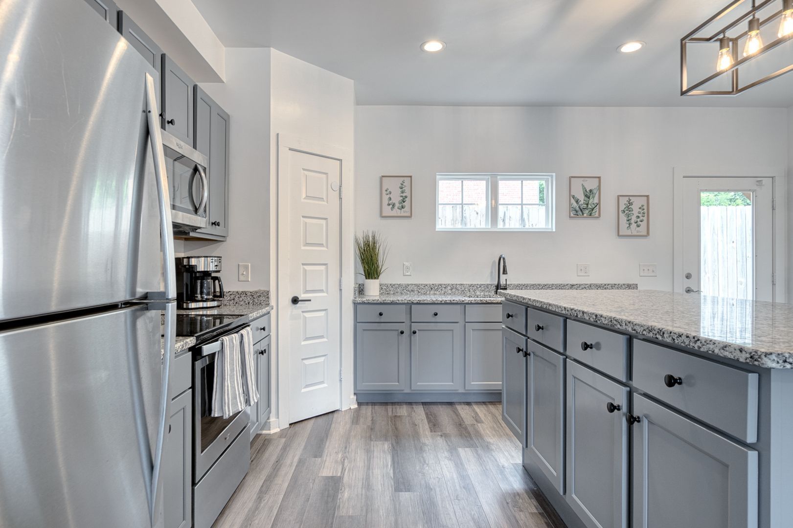 Gray and white kitchen with stainless steel appliances and granite countertops.