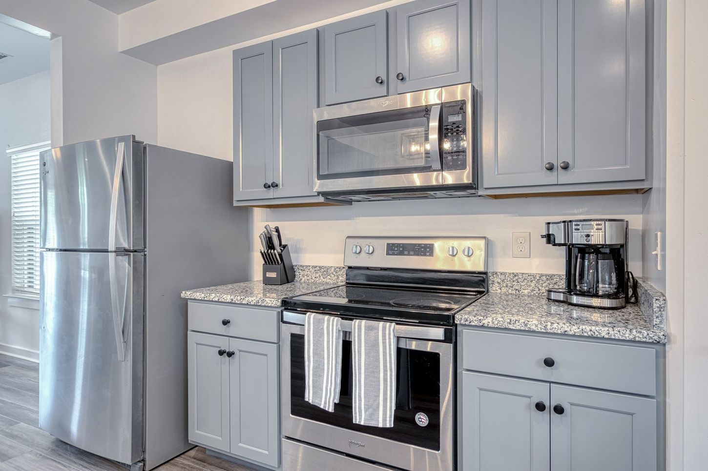 Gray kitchen with stainless steel appliances, cabinets, and countertop.