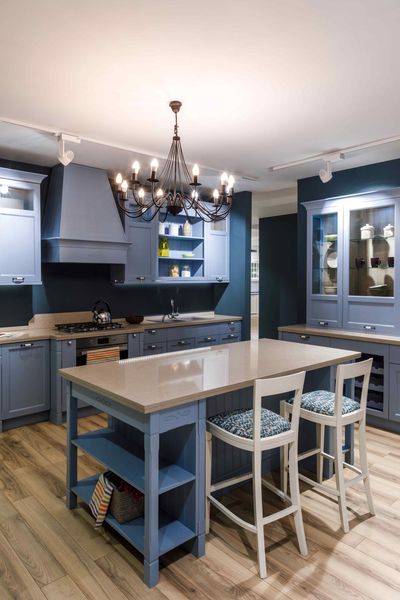 Handyman Maple Ridge: A kitchen with blue cabinets and a large table in the middle