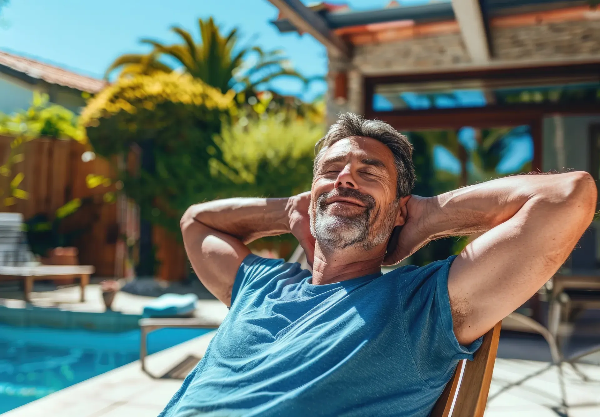 man relaxing next to pool in backyard man relaxing next to pool in backyard