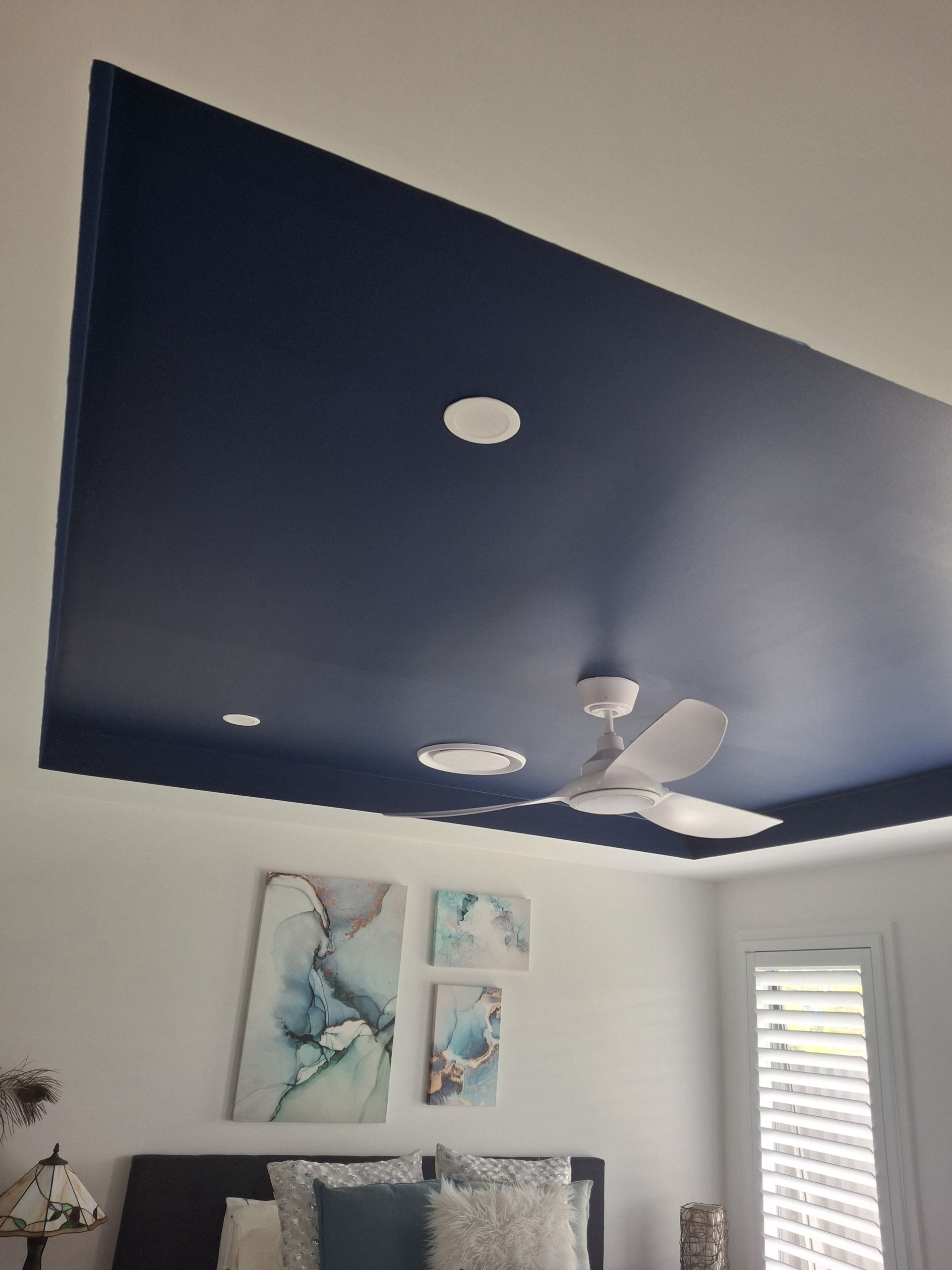 A Man is Painting a Wall With a Paint Roller — A-Z Property Painting In Karuah, NSW