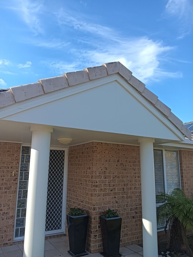 A Person is Painting a Roof With Blue Paint — A-Z Property Painting In Karuah, NSW