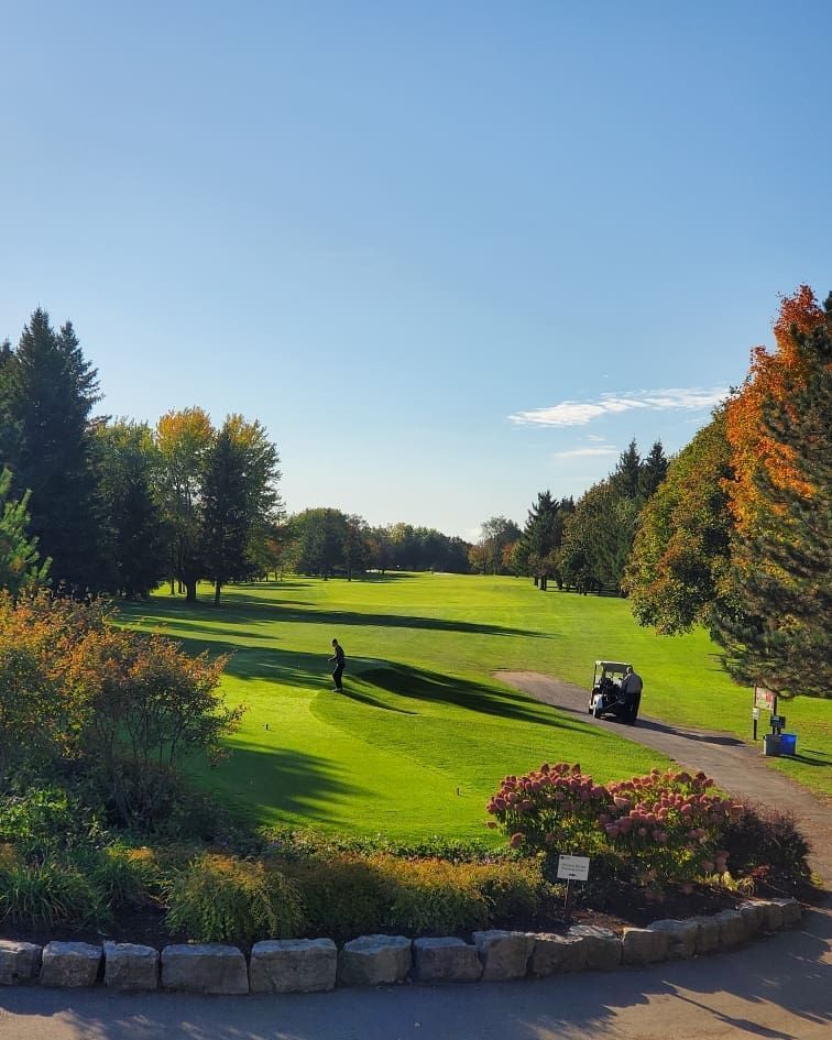 Wide shot of Kedron Dells Golf Club with a golfer and a parked cart on a path.