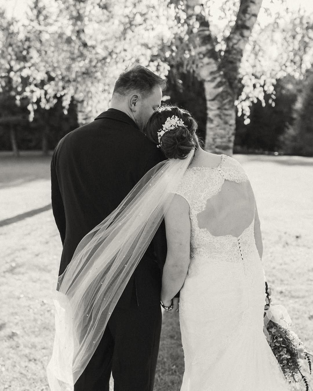 A black and white photo of a bride and groom standing next to each other.