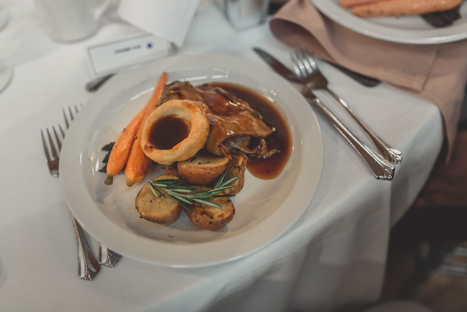 A plate of food is sitting on a table with utensils.