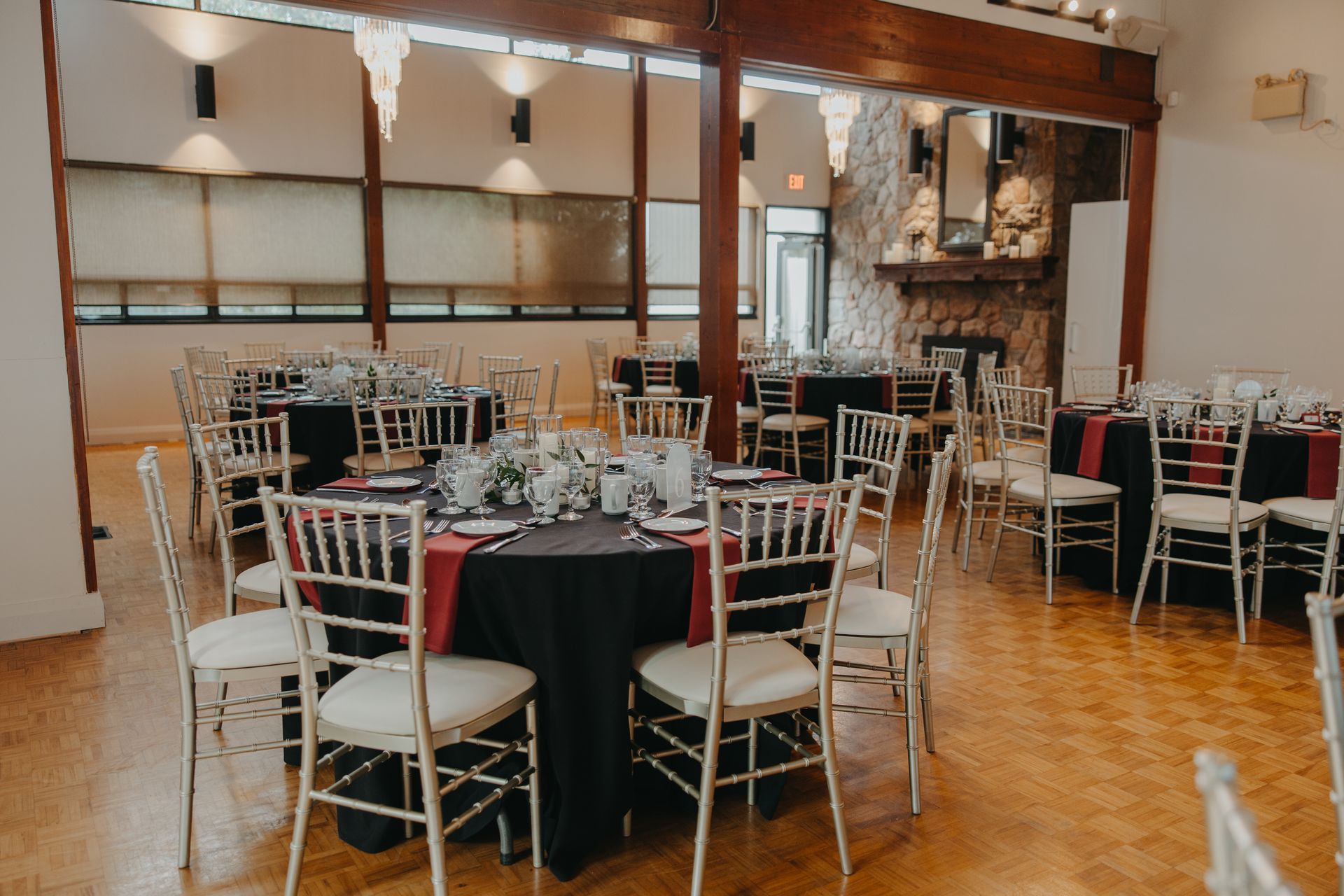 A large room with tables and chairs set up for a wedding reception.