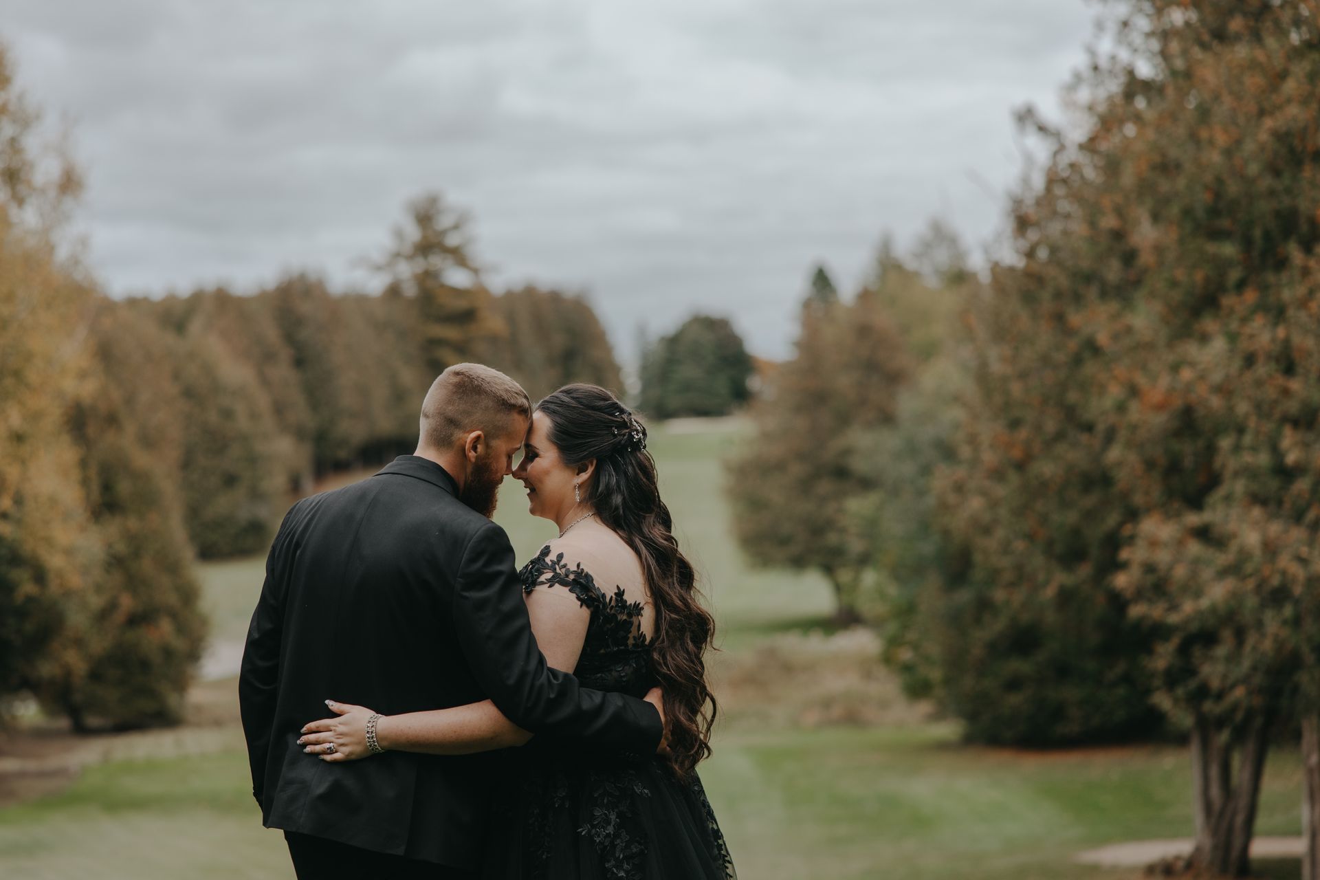 A bride and groom are standing next to each other on a golf course.